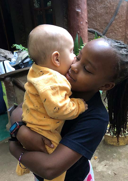 Fille qui tient un bebe dans ses bras