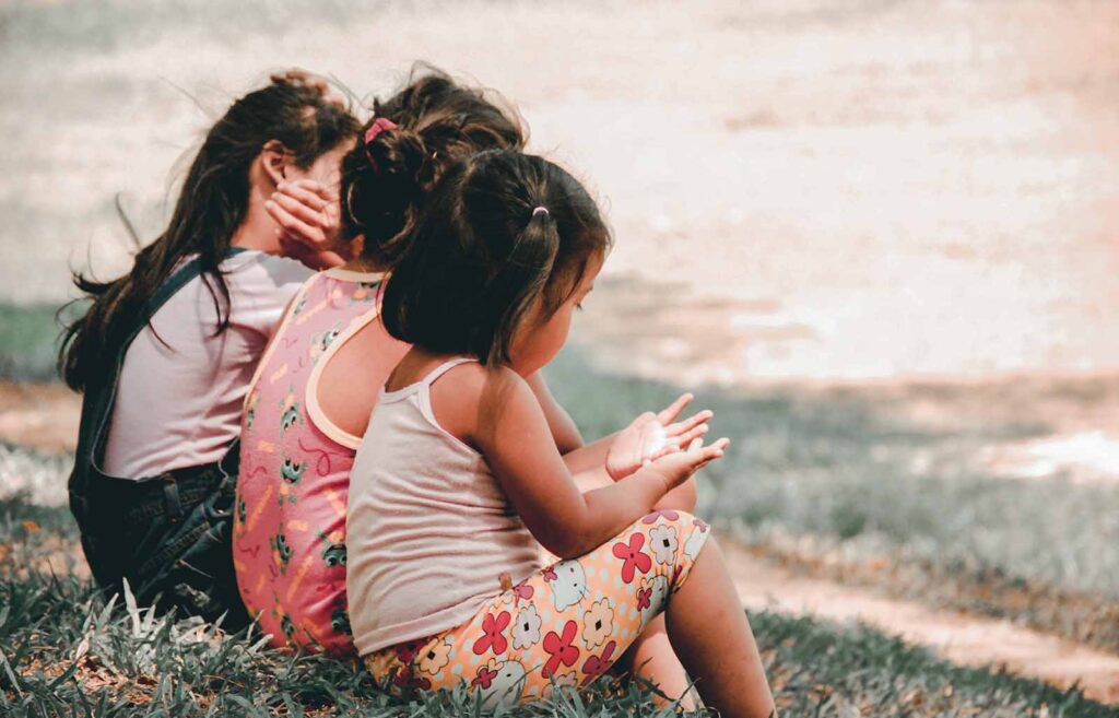 enfants assis dans l'herbe