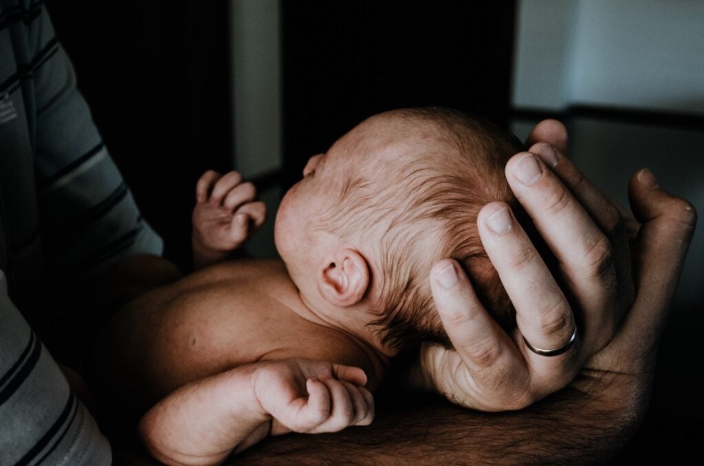 bebe dans les bras de son papa tenir la tete