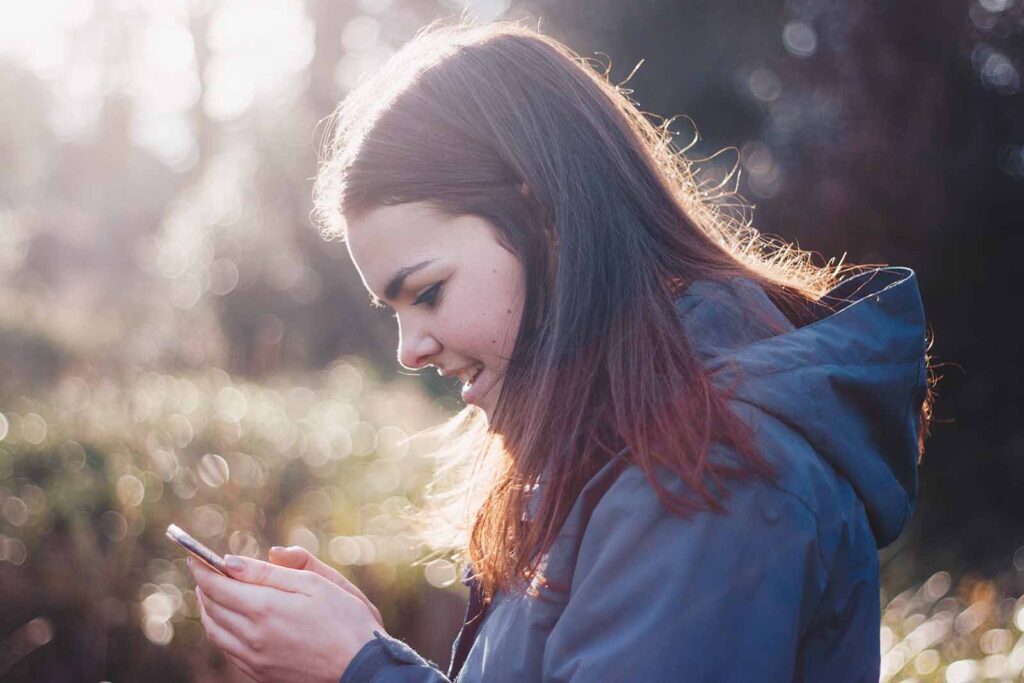 femme dans la forêt sur son téléphone mobile