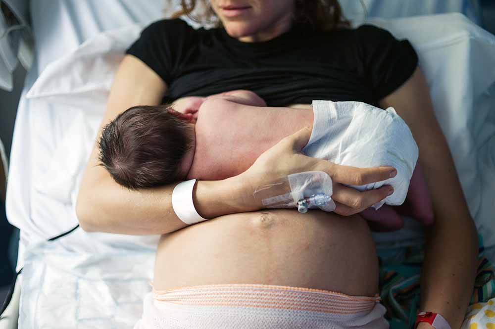 mère allaite son nourrisson dans les bras après l'accouchement