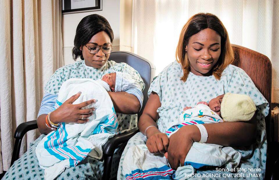 Deux soeurs souriantes tenant chacune leur nouveau-né dans une chambre d'hôpital, représentant un événement rare et joyeux de naissances simultanées dans une famille, symbolisant un accouchement et une naissance insolite et synchronisée.