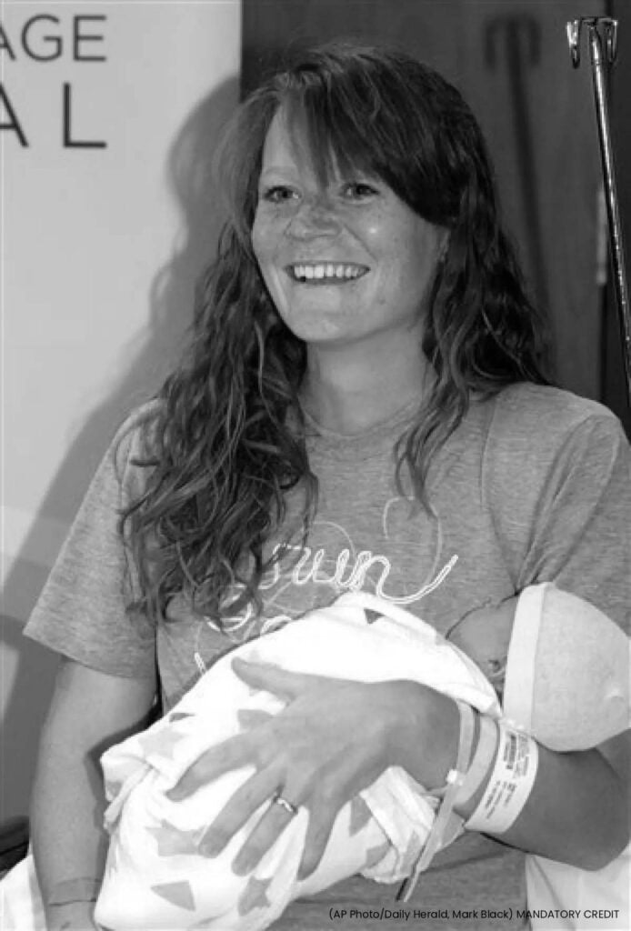 Jeune mère radieuse tenant son nouveau-né, illustrant une naissance remarquable post-marathon, mettant en avant le thème de l'accouchement et de la maternité chez les femmes sportives et les scénarios de naissance extraordinaires.