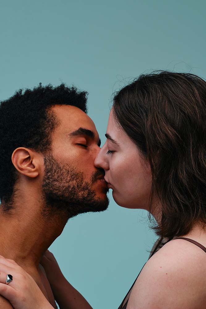 Portrait intime d'un couple s'embrassant tendrement, mettant en évidence l'importance de l'affection et de la proximité dans la sexualité pendant la grossesse. L'image souligne la nécessité de maintenir une connexion émotionnelle profonde et une intimité physique adaptée à cette étape de la vie.