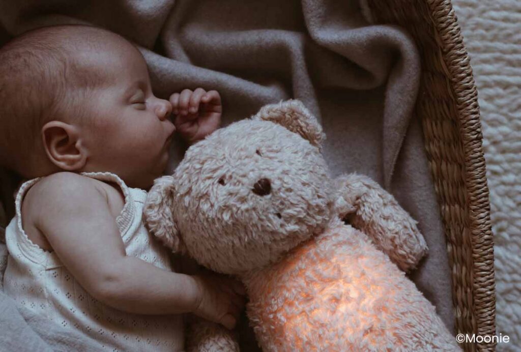 Bébé dormant profondément avec une peluche, illustrant la technique du Chrono-Dodo pour un sommeil paisible et réparateur des nourrissons.