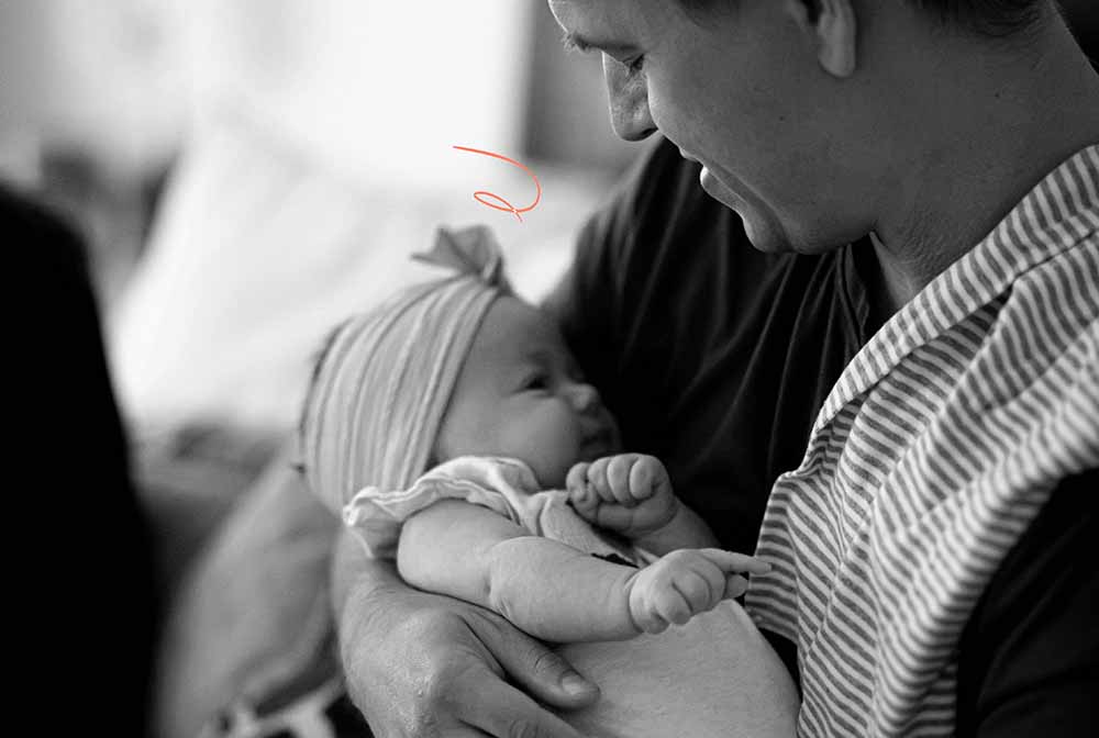 Un père aimant tenant son bébé dans ses bras, échangeant un regard complice, illustrant son rôle essentiel de soutien dans l'expérience de l'allaitement maternel et le renforcement du lien père-enfant.