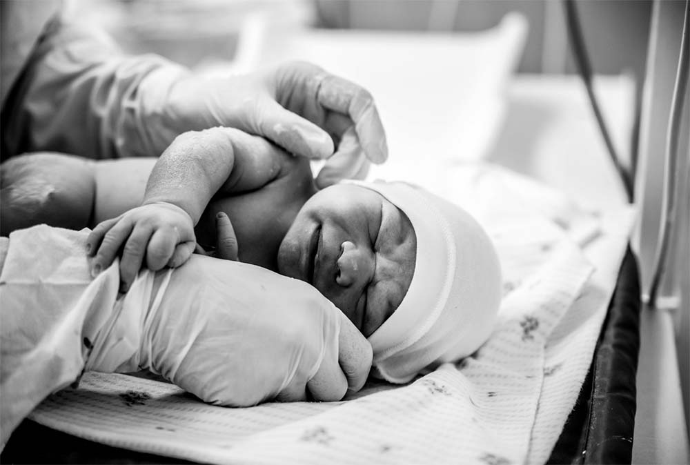 Premiers moments après la naissance : une introduction douce à la vie, illustrée par les soins néonatals immédiats et le contact peau à peau en salle d'accouchement.