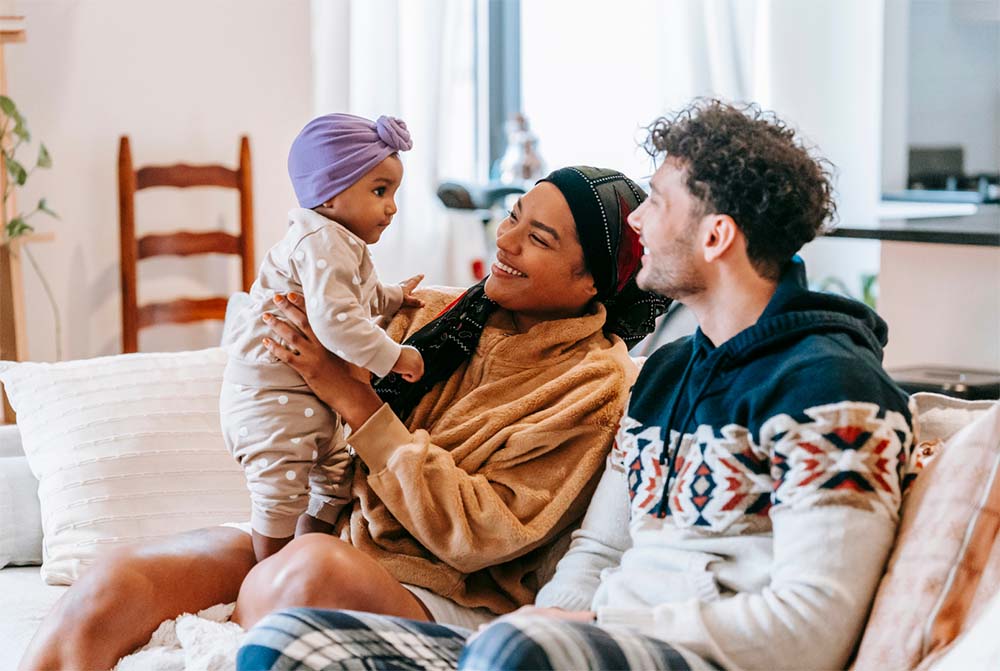 La joie de l'adoption : un couple partage un moment tendre avec leur bébé adopté, illustrant la chaleur et l'amour d'un foyer accueillant un nouvel enfant