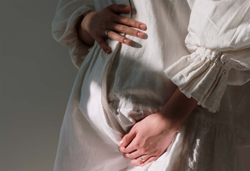 Attente calme avant l'accouchement : une femme enceinte se repose, attentive aux signes d'un accouchement imminent, dans un environnement paisible et intime