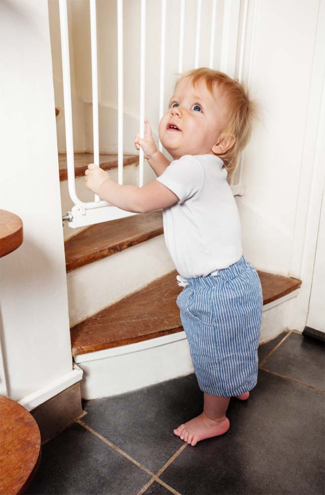 Bébé explorant une barrière de sécurité à l'escalier : Renforcez la sécurité de votre maison pour les enfants avec des dispositifs adaptés. Informations et astuces pour un foyer sécurisé pour les bébés.