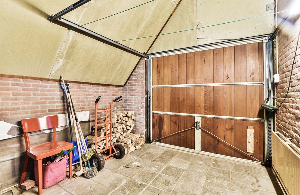 Garage avec porte en bois et outils non sécurisés : Optimisez la sécurité dans les espaces de rangement pour prévenir les accidents domestiques. Protégez votre enfant avec nos recommandations pour un habitat sécurisé.