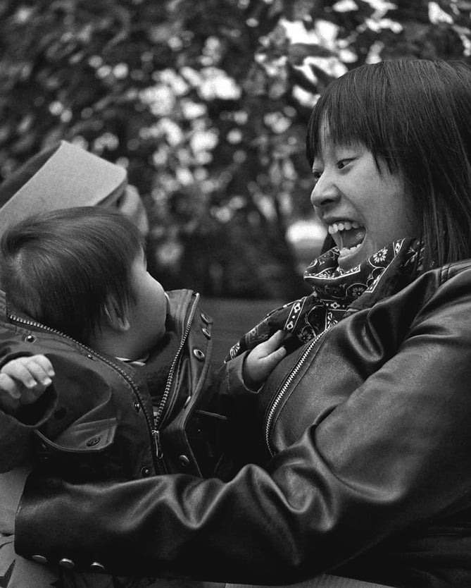 Parents avec premier enfant : moment de rire et complicité entre maman et bébé en noir et blanc