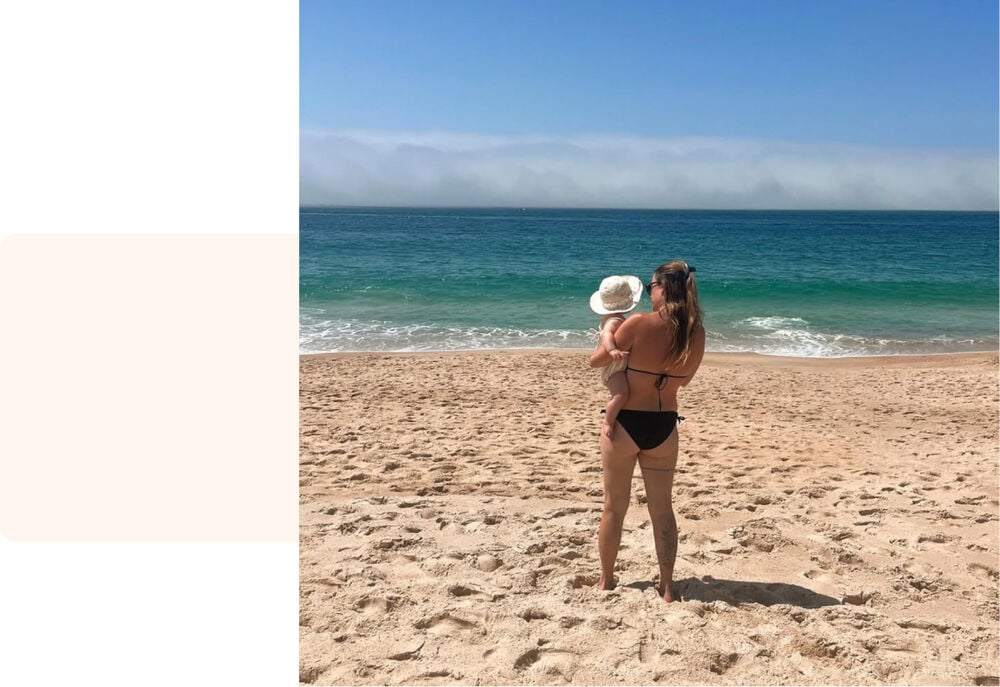 Maman et bébé à la plage face à l'océan, portrait premiers moments mère-fille