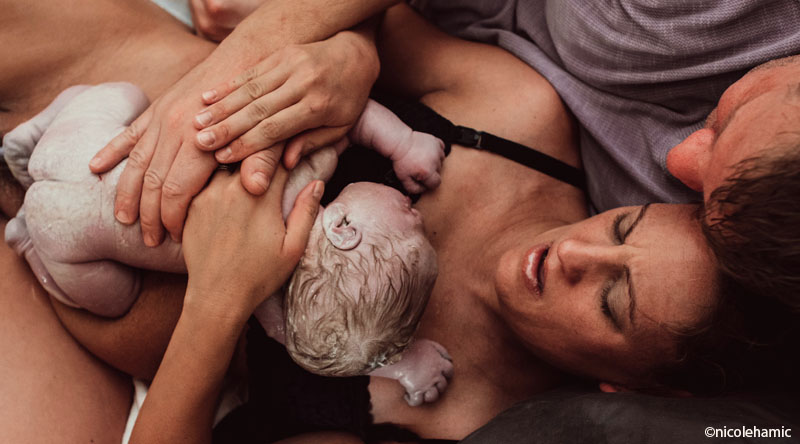 Accouchement naturel sans péridurale, intensité de la naissance physiologique, premières minutes peau à peau avec bébé tout juste né dans les bras de maman et papa