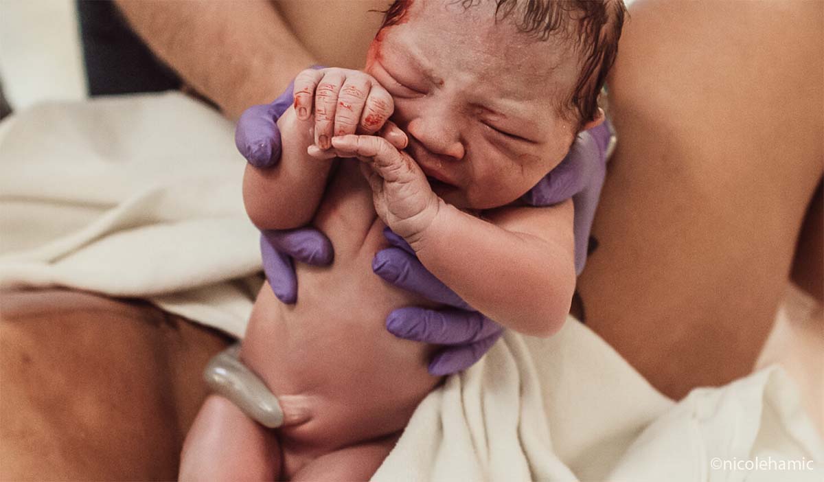 Naissance physiologique sans péridurale, bébé juste né dans les bras, accouchement naturel intense et sans médicalisation, ambiance intimiste à la maternité