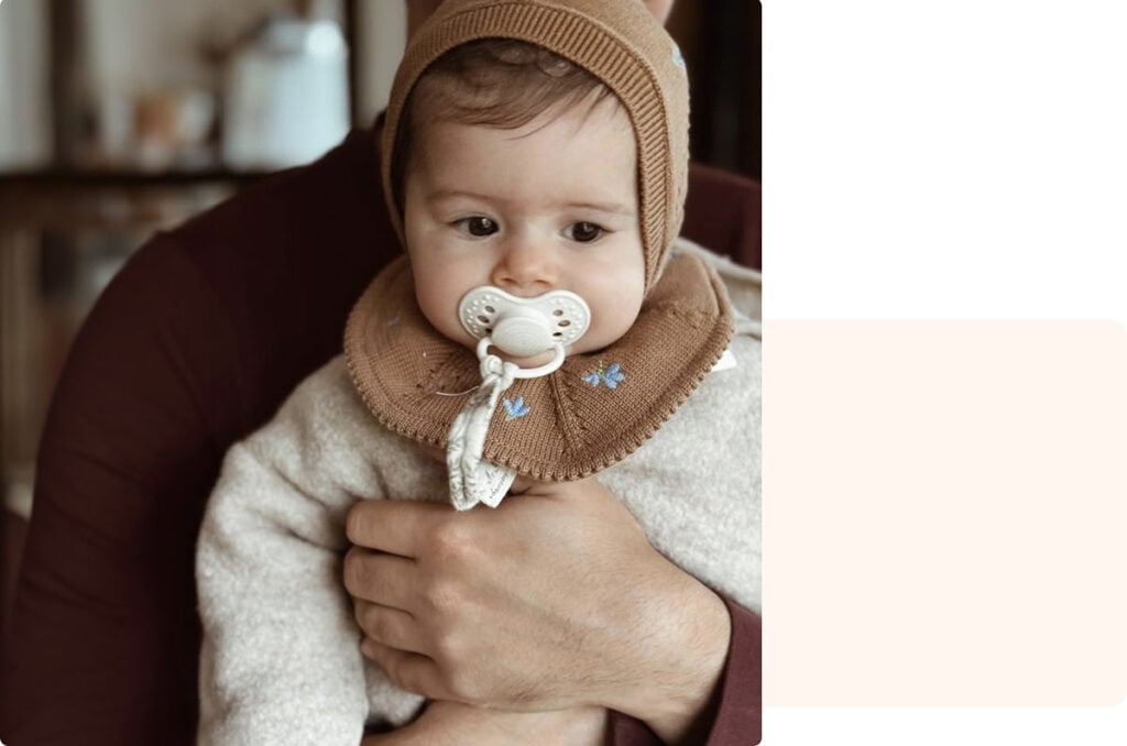 Bébé dans les bras d’un parent, moment tendre souvent évoqué dans un témoignage maman sur les premiers mois