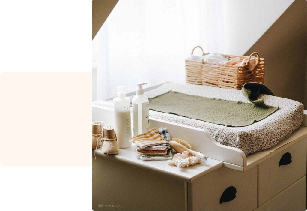 Coin à langer pratique avec panier en osier et produits de soin naturels, baigné de lumière douce