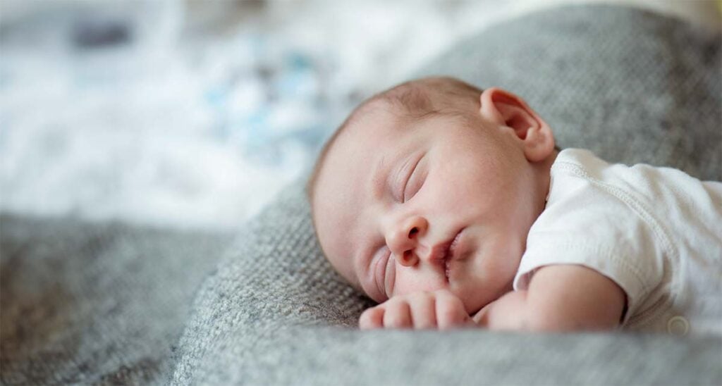 Bébé dormant paisiblement après la naissance, scène de repos observée lors d’un accompagnement par une sage-femme post-partum