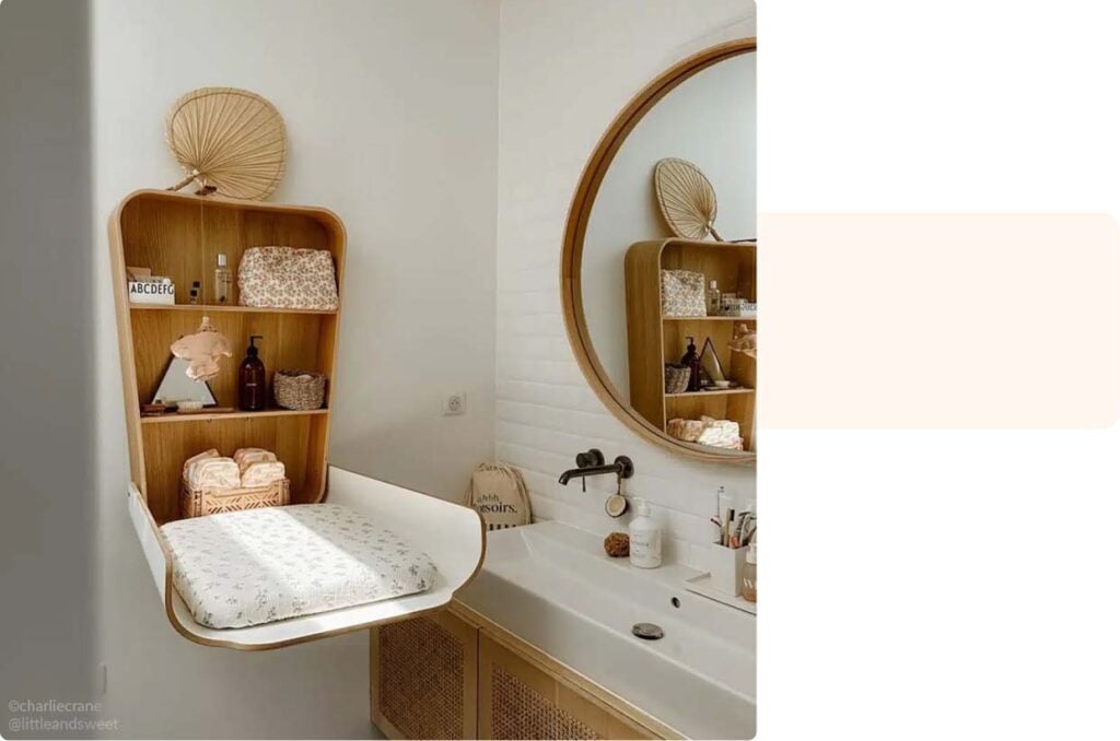 Espace salle de bain aménagé avec un coin à langer mural et accessoires de toilette bébé dans un style minimaliste