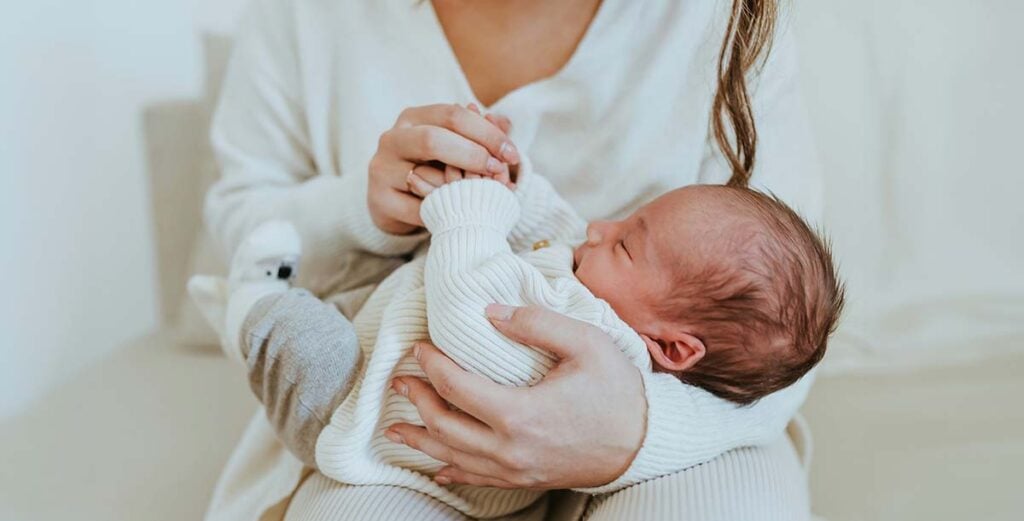 Bébé blotti contre sa mère, instant de complicité et de bien-être encouragé par une sage-femme post-partum