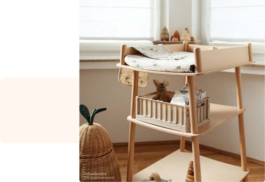 Coin à langer scandinave avec matelas à motifs et rangement en rotin, prêt pour le change du nourrisson