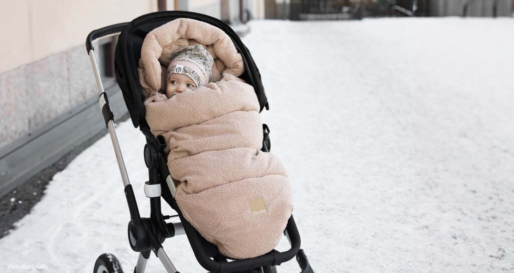 Équipement bébé neige pour les vacances à la montagne : chancelière chaude, combinaison et bonnet pour garder bébé bien au chaud sur la neige.