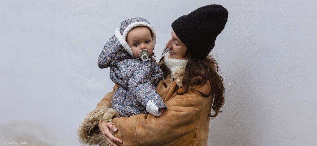 Idées de tenues pour habiller bébé au ski pendant les vacances neige, avec vêtements en laine et combinaison isolante.