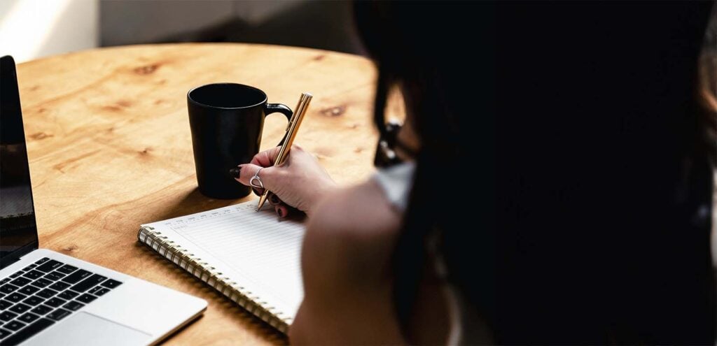 Carnet de notes et calculatrice utilisés pour planifier les dépenses et optimiser les aides financières naissance bébé avant l’arrivée de l’enfant