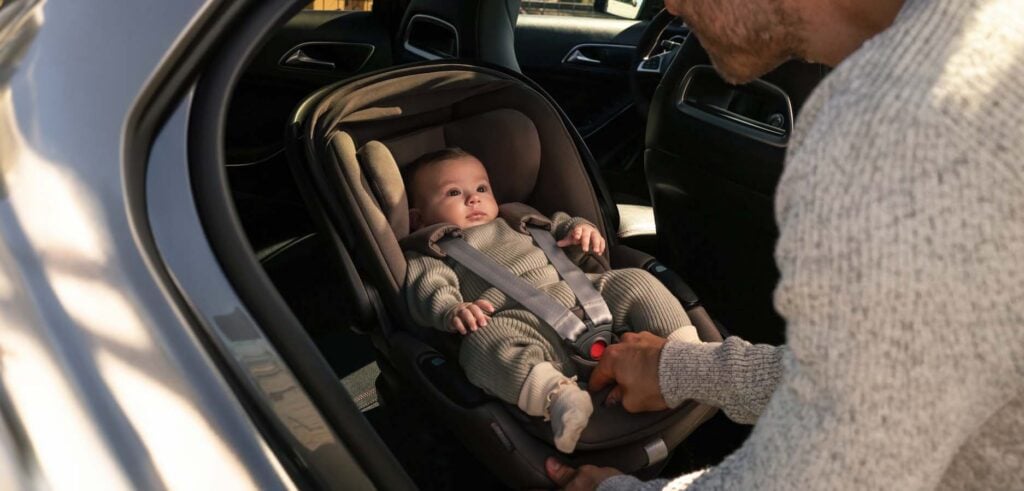 Bébé installé dans la nacelle Inglesina utilisée comme siège auto, poussette évolutive avec nacelle homologuée pour le voyage en voiture dès la naissance