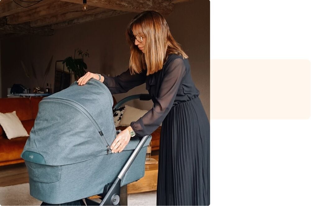 Manon penchée sur sa poussette à la maison, témoignage sur le quotidien de devenir maman pour la première fois