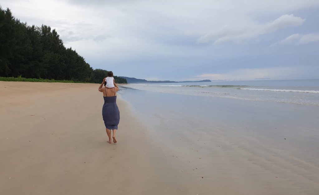 maman porte son bébé sur la plage