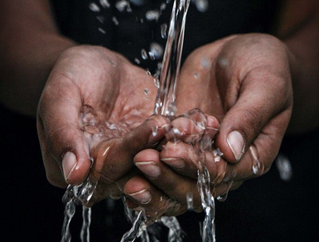 Mains sous une fontaine d'eau