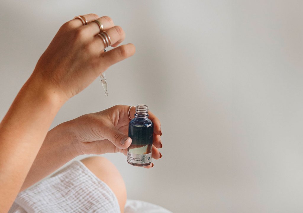 Image d'une sélection de produits cosmétiques naturels et hypoallergéniques, huile, maquillage, disposés élégamment sur une table en bois clair. Ces produits sont étiquetés comme étant sûrs pour les femmes enceintes, mettant l'accent sur la douceur et l'absence de produits chimiques nocifs.