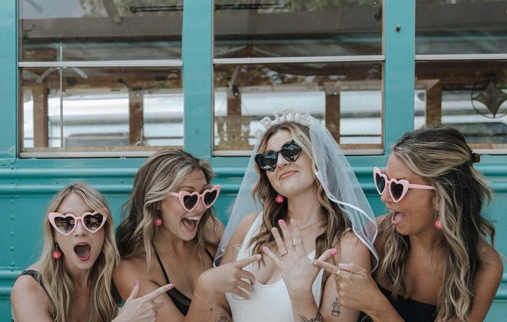 Activité parfaite pour un enterrement de vie de jeune fille avec une future maman enceinte : groupe d'amies célébrant avec des lunettes en forme de cœur. Idées d'EVJF amusantes et mémorables.