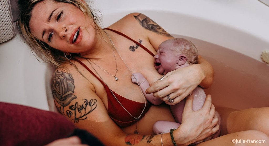 Accouchement naturel, tout savoir avant de se lancer, naissance dans l’eau sans intervention, image maman tatouée portant bébé après sortie