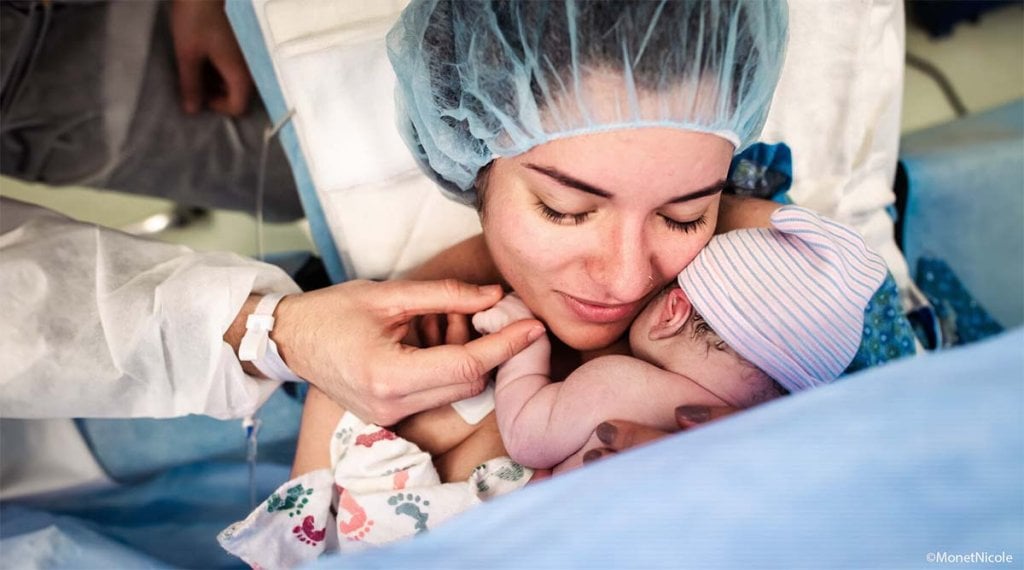 Accouchement par césarienne en douceur, moment tendre bloc opératoire, maman embrasse bébé juste après naissance par voie haute, accouchement respecté en bloc opératoire, premier câlin après césarienne, moment fort accouchement chirurgical