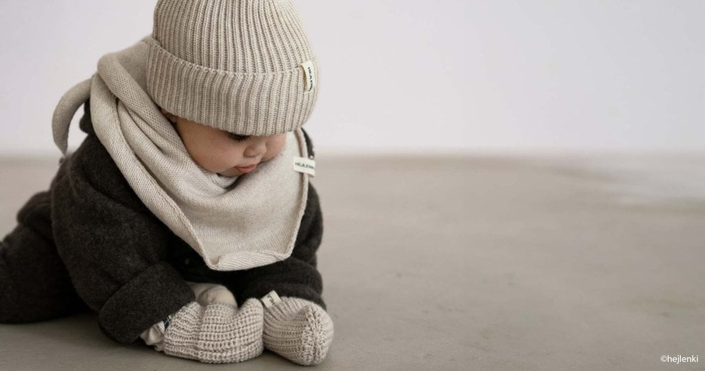 Bébé emmitouflé dans un manteau chaud avec bonnet et écharpe indispensables pour sorties hivernales