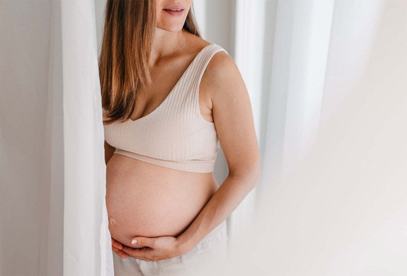 Femme enceinte adoptant des méthodes douces pour déclencher le travail naturellement et accélérer l'accouchement, incluant des positions spécifiques et des mouvements recommandés par des experts.